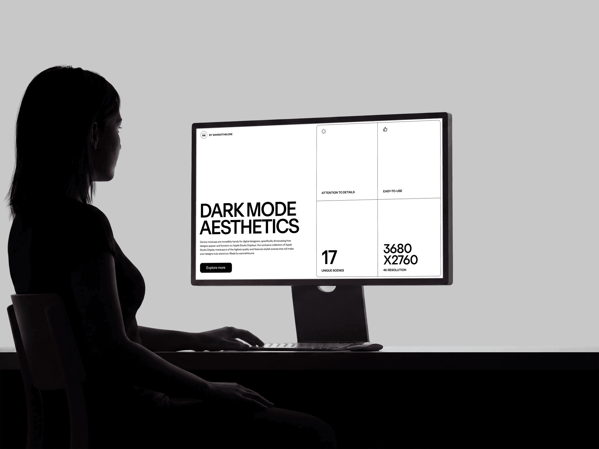 Two human figures shown in shadow looking at a computer monitor mockup in dramatic dark light