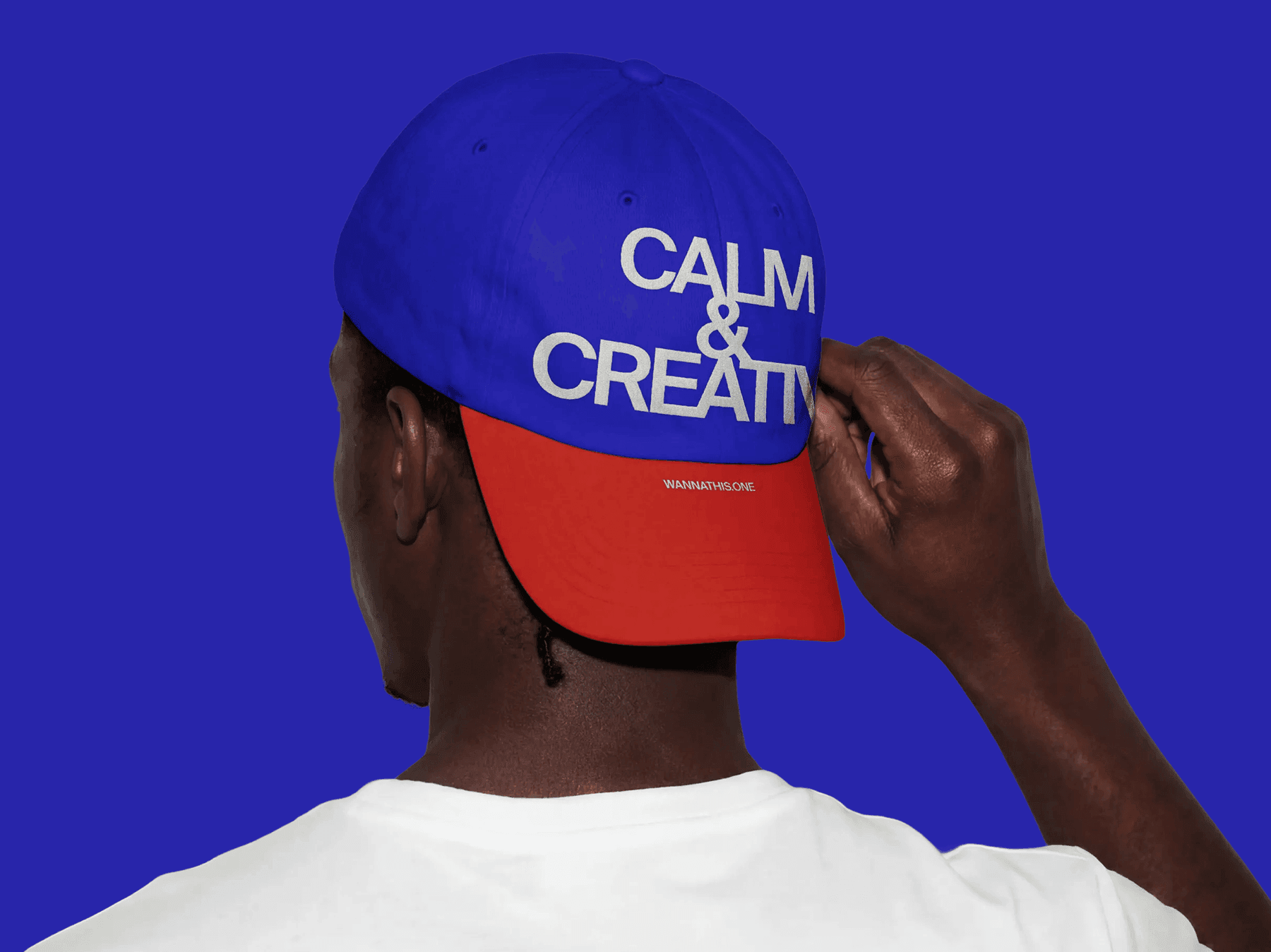 Back view of a person wearing a baseball cap in a studio setting