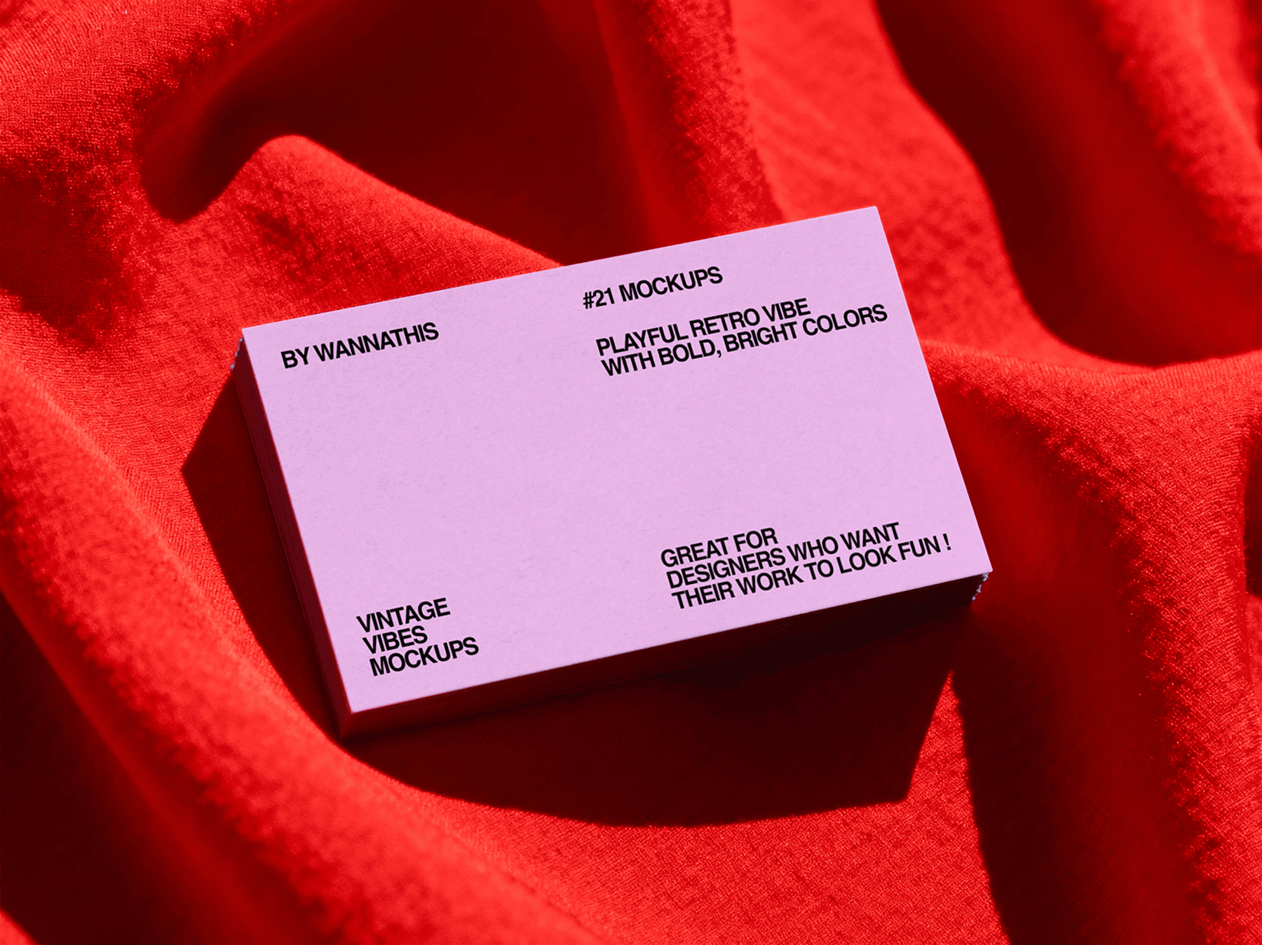 Business card mockup lying on soft red fabric surface