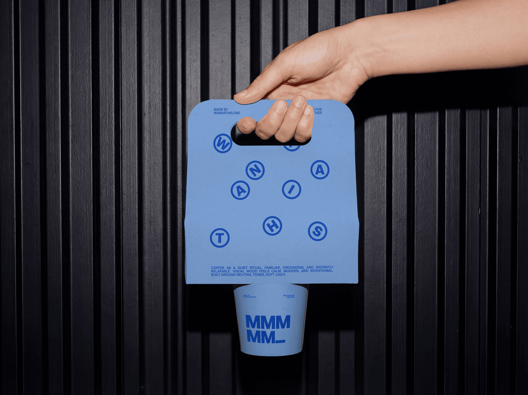 Close-up of a hand holding a takeaway coffee holder with cup