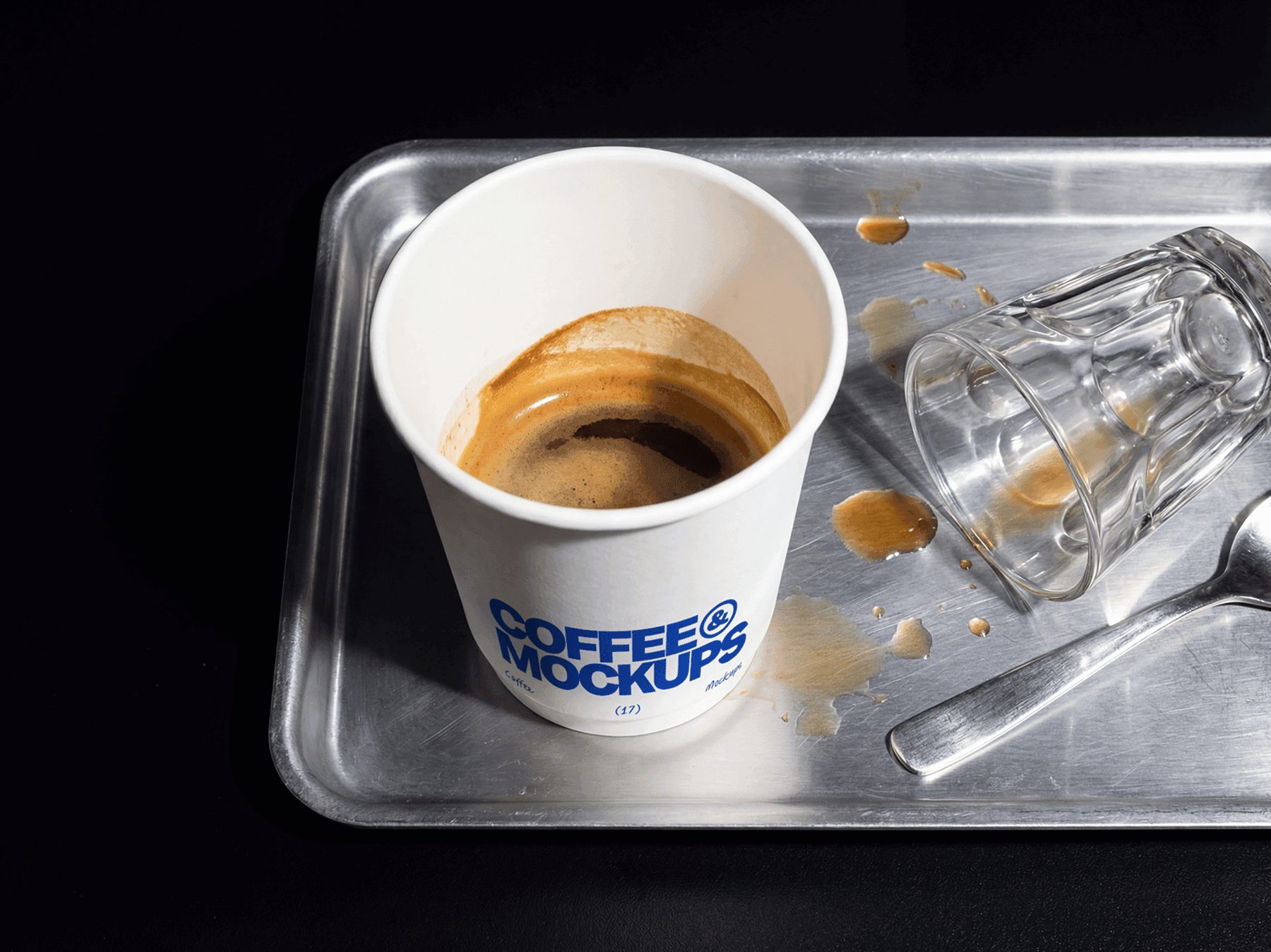 Takeaway coffee cup placed on a metal tray with glass and spoon