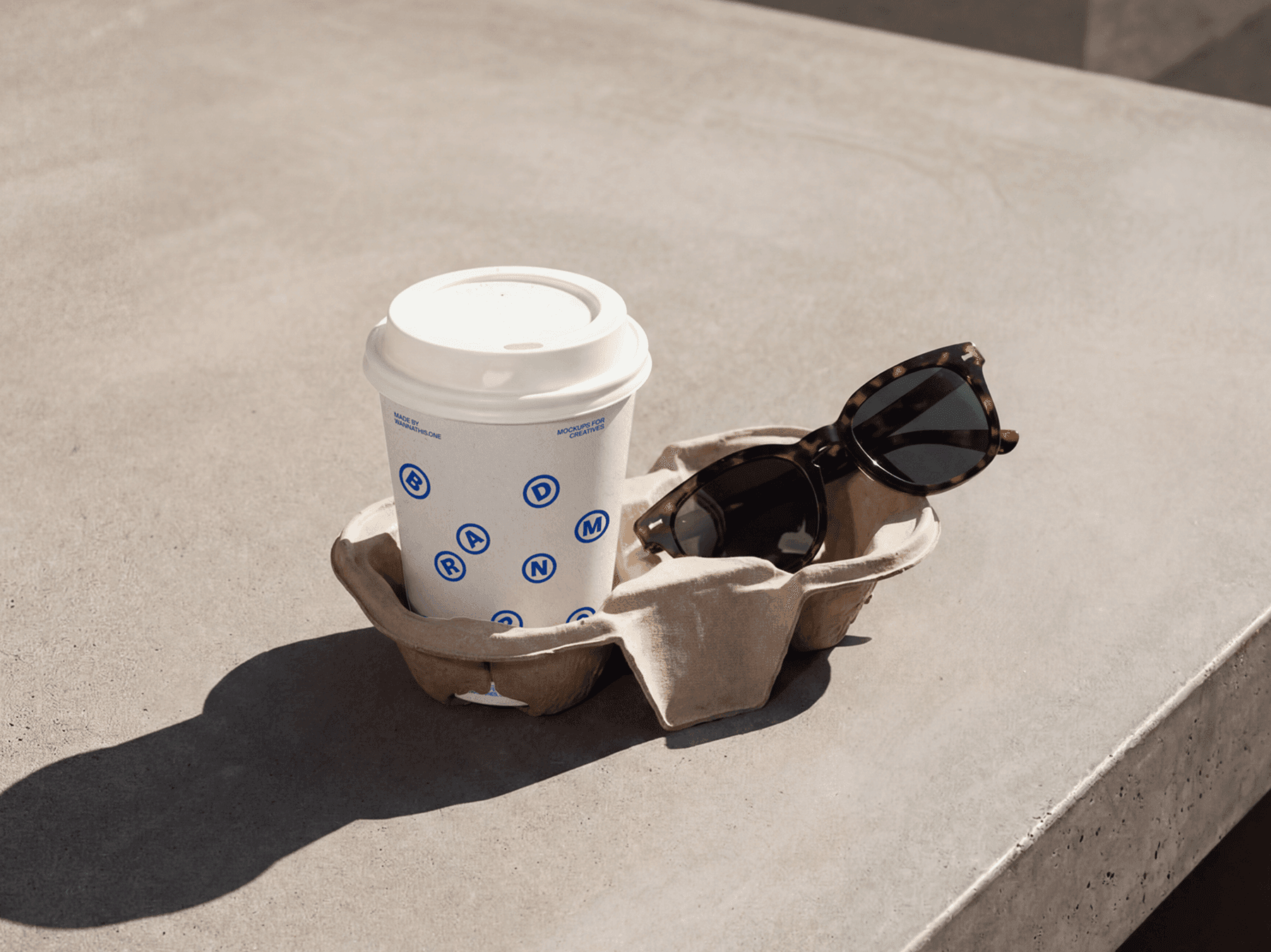 Takeaway coffee cup placed in a cardboard carrier on a table