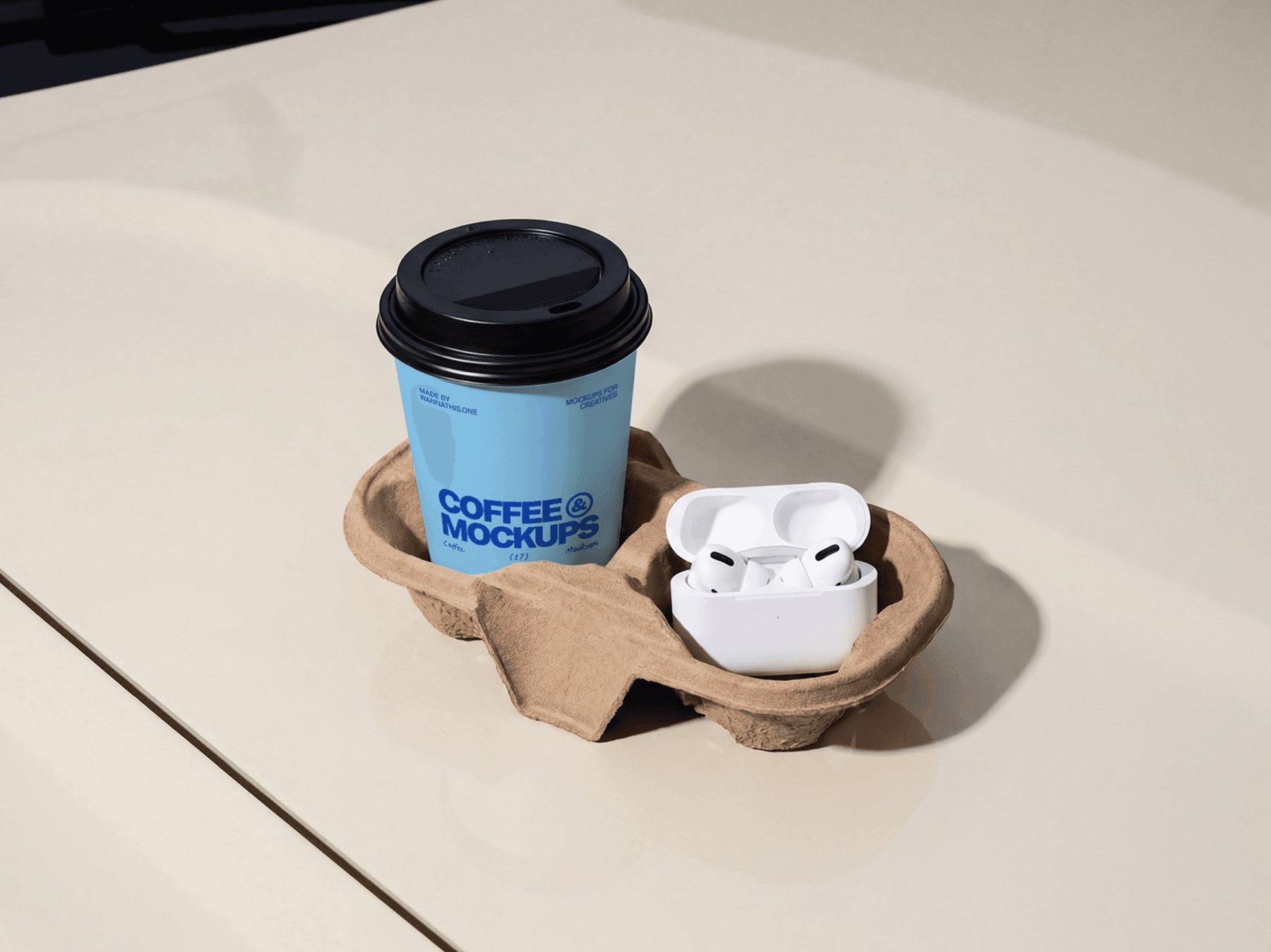 Takeaway coffee cup in a carrier with small accessories on a table