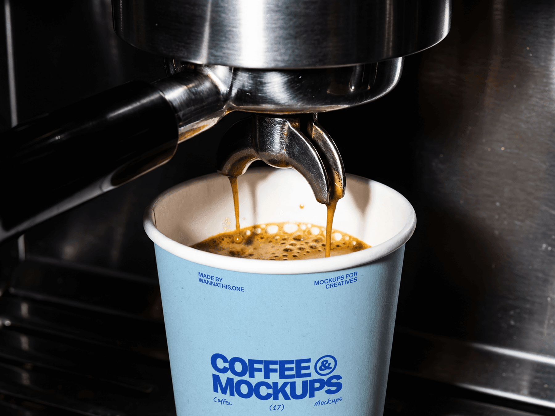 Takeaway coffee cup placed under an espresso machine while coffee is pouring