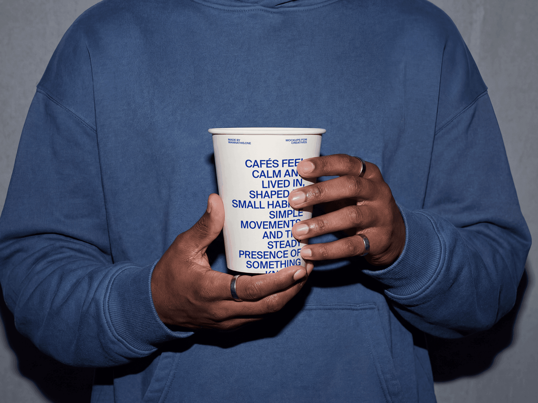 Person holding a takeaway coffee cup with both hands