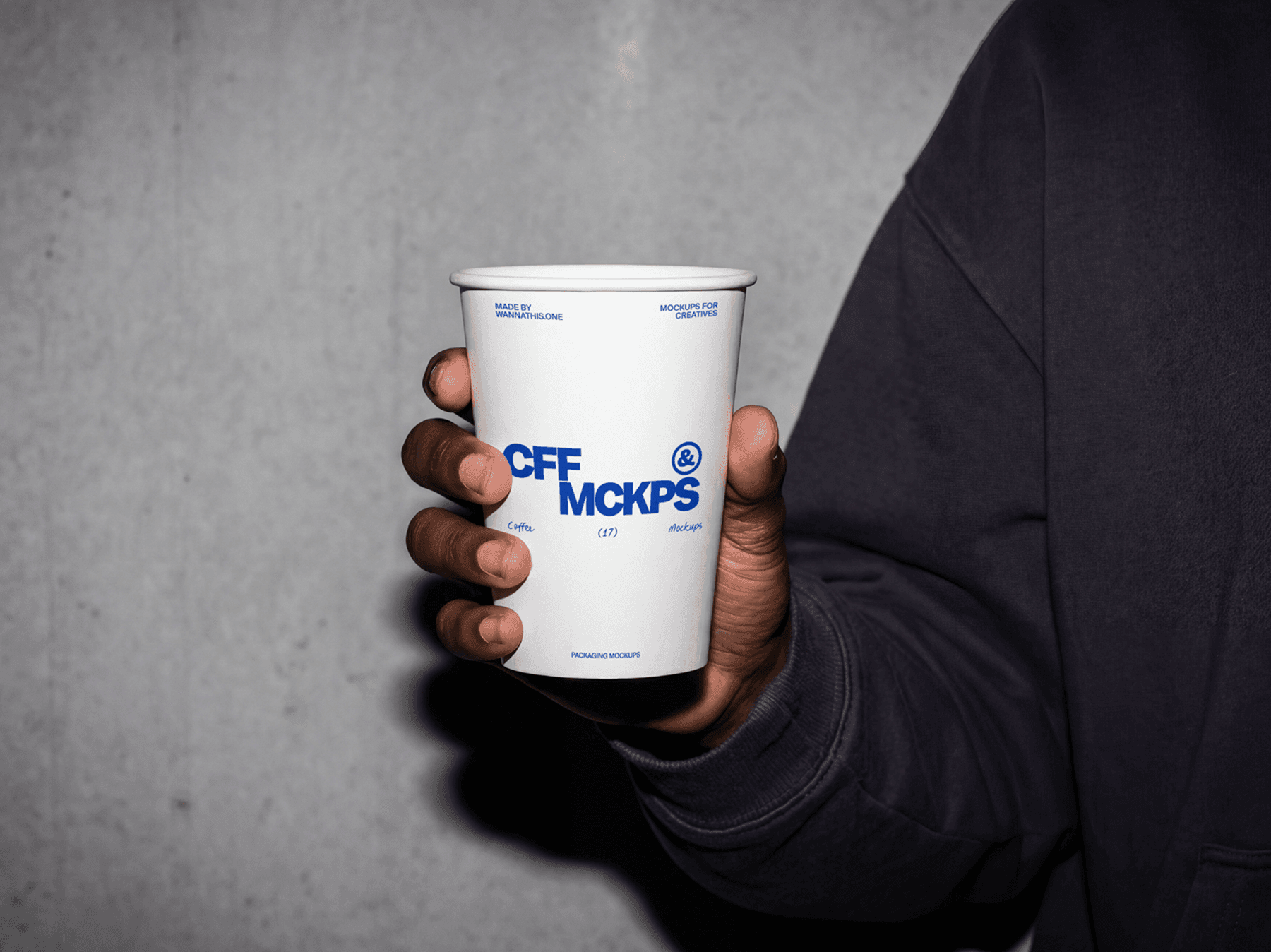 Close-up of a person holding a takeaway coffee cup in one hand