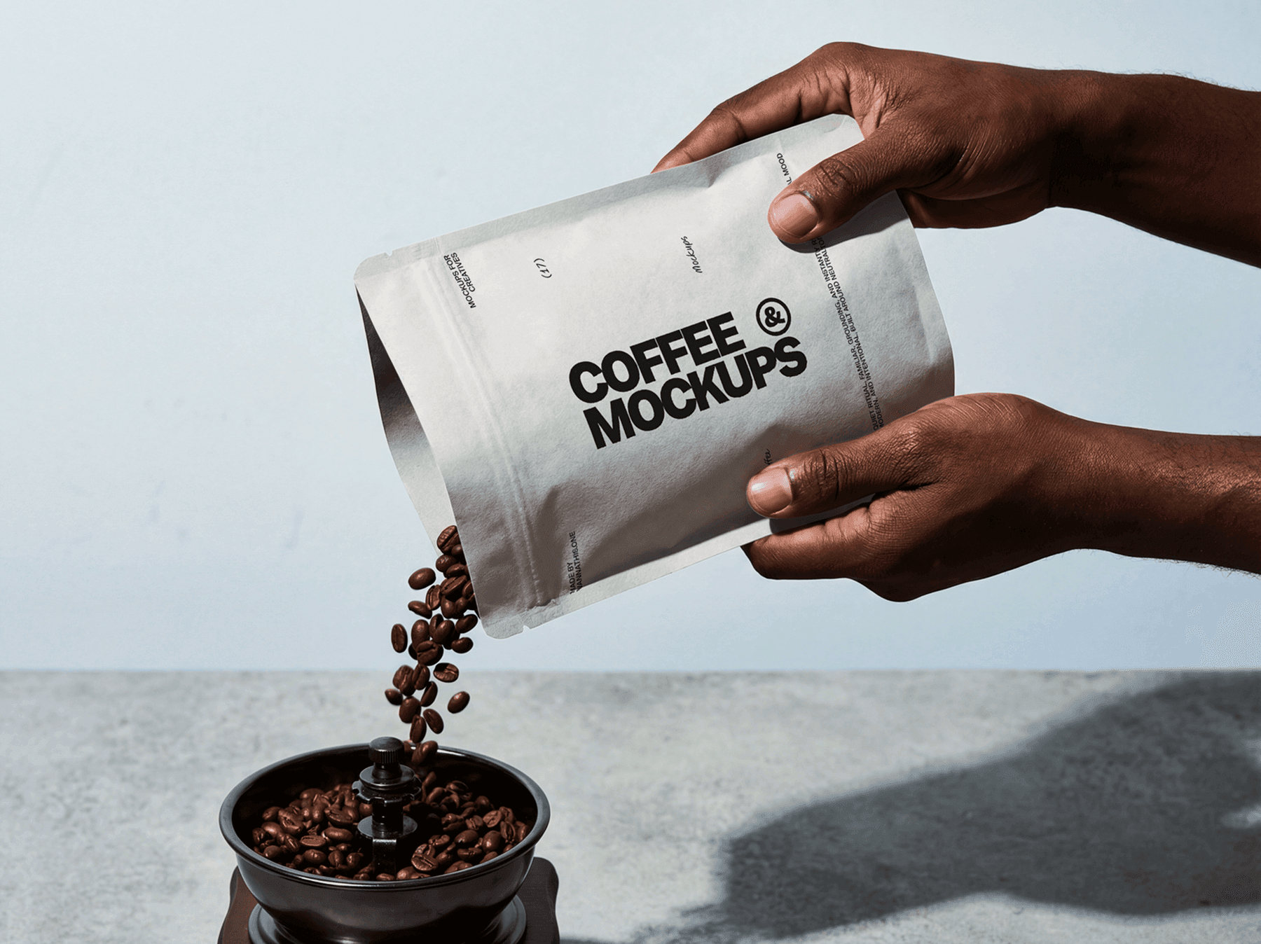 Hands pouring coffee beans from a branded coffee bag into a grinder