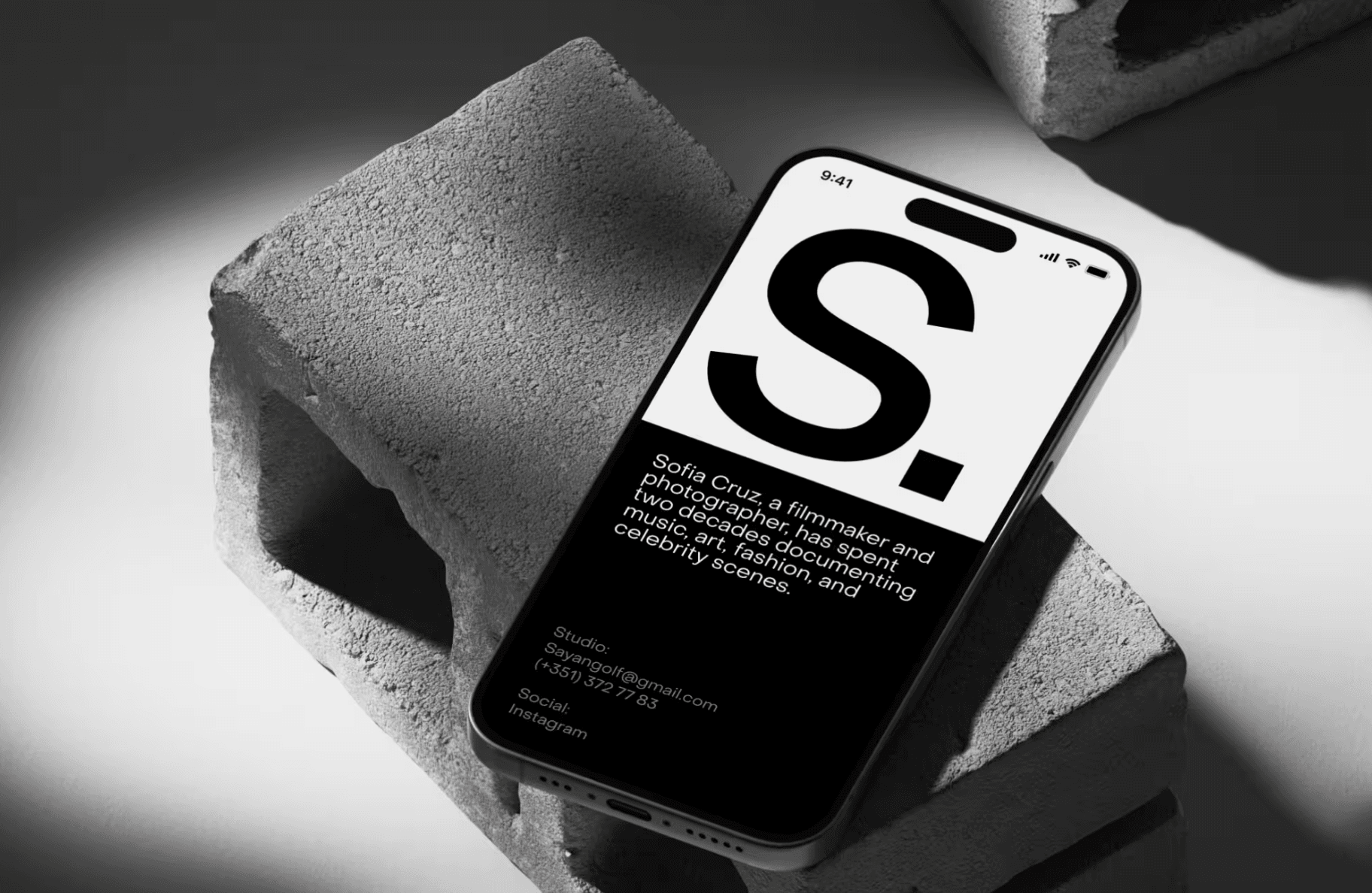 iPhone mockup on concrete block with modern black and white portfolio layout