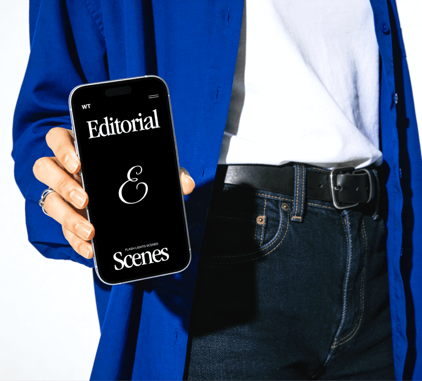 iPhone editorial mockup held by person in modern outfit with editable screen design