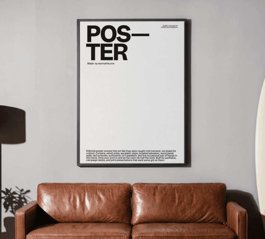 Framed editorial poster mockup on a grey wall above a brown leather sofa, bold POSTER type on the print, with a floor lamp, plant, and surfboard nearby.