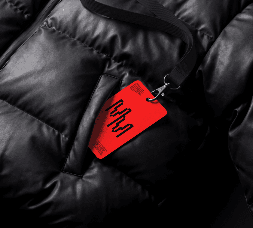 Pass card mockup clipped to a lanyard and resting on a padded puffer jacket with a slash pocket.