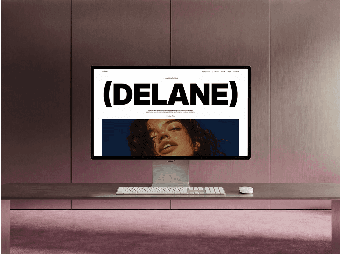 Delane Framer portfolio template on a Studio Display against a pink wall, bracketed name headline over an editorial portrait, a template for digital designers