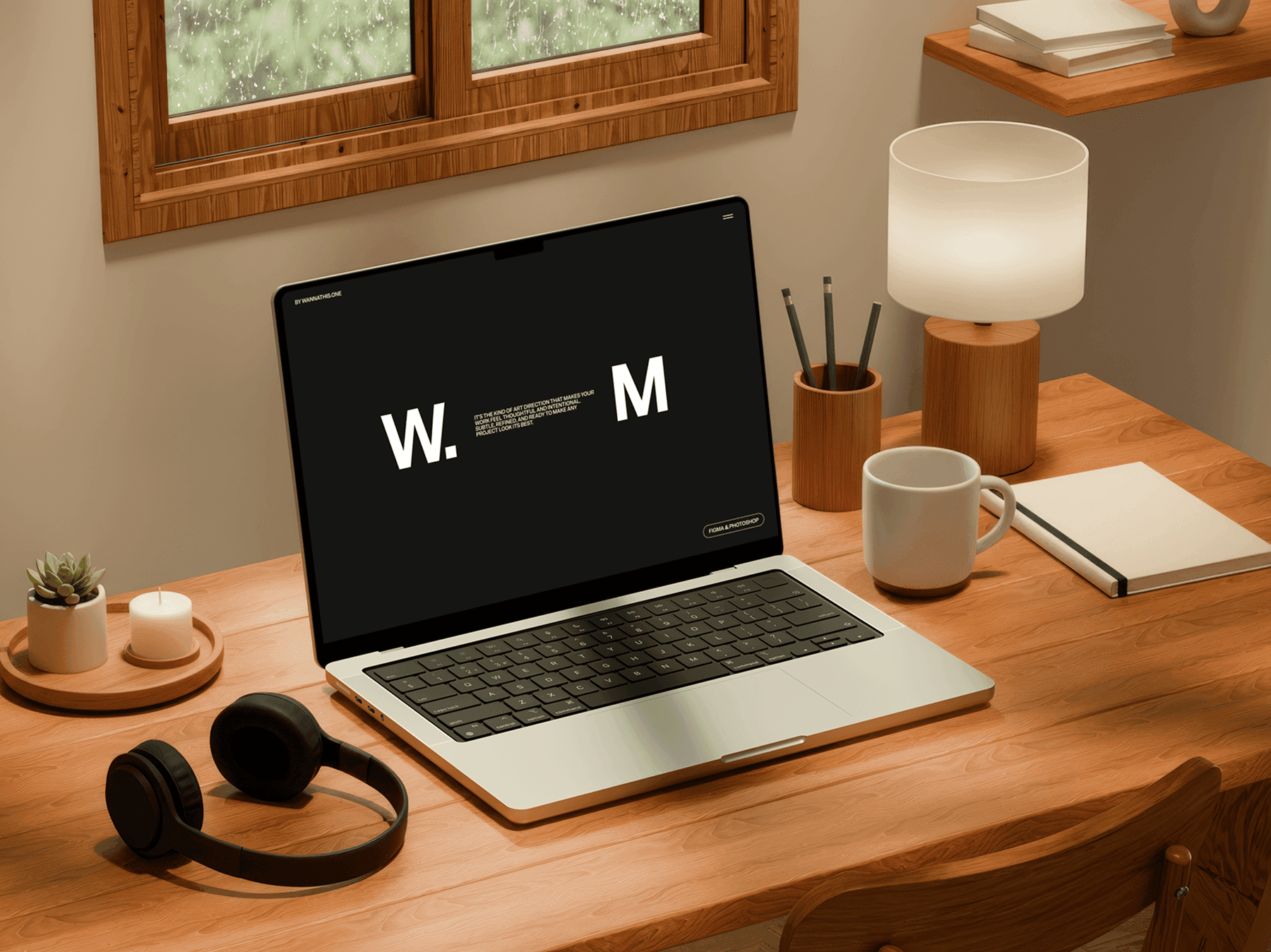 MacBook mockup positioned on a wooden desk with decor items