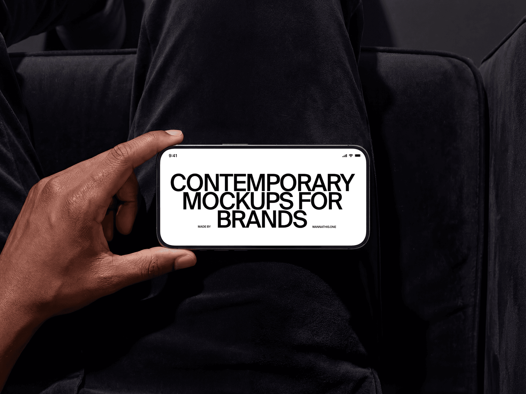 Hand holding an iPhone in horizontal position while seated indoors