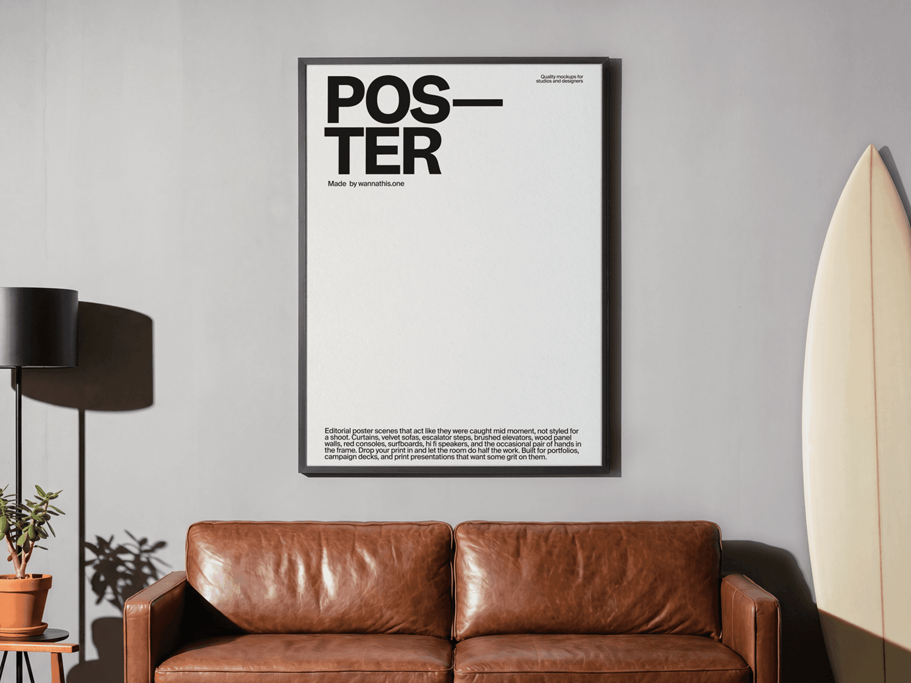 Large framed editorial poster mockup hanging above a leather sofa in a refined modern interior living scene