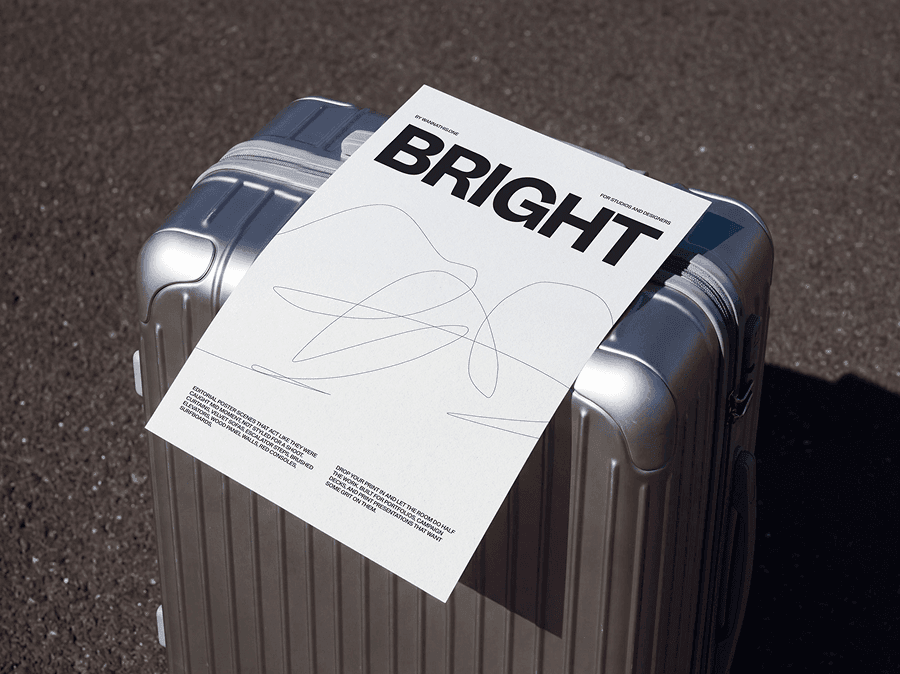 Editorial poster mockup laid on top of a refined travel suitcase outdoors in a natural lifestyle scene