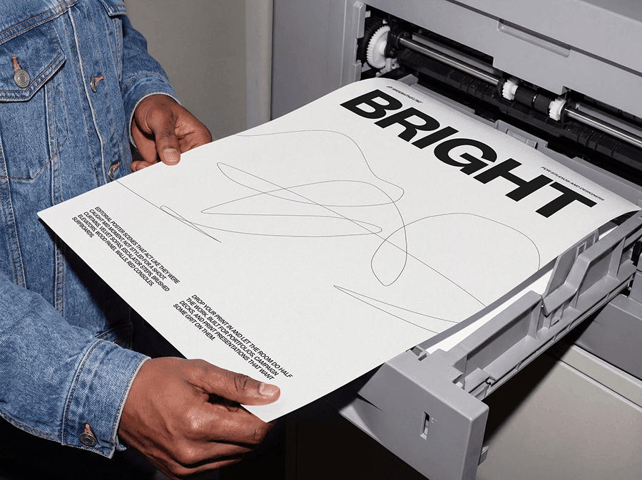 Person holding a freshly printed editorial poster mockup near a refined print press machine in studio scene