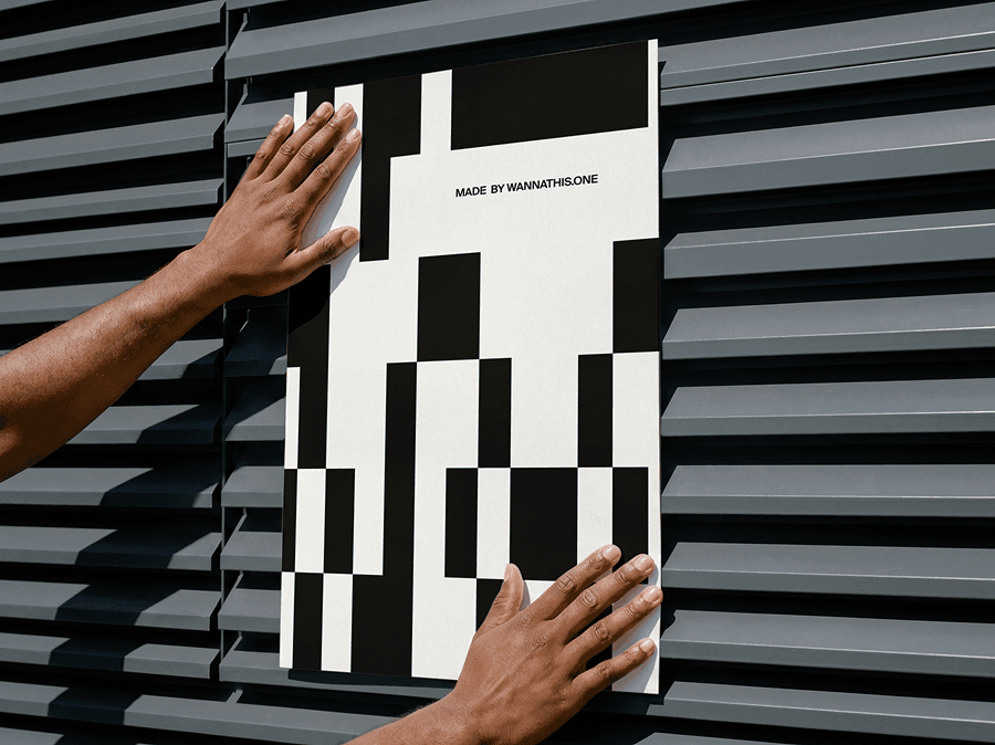 Hands placing an editorial poster mockup on a sleek refined metal wall surface in a bold modern studio scene