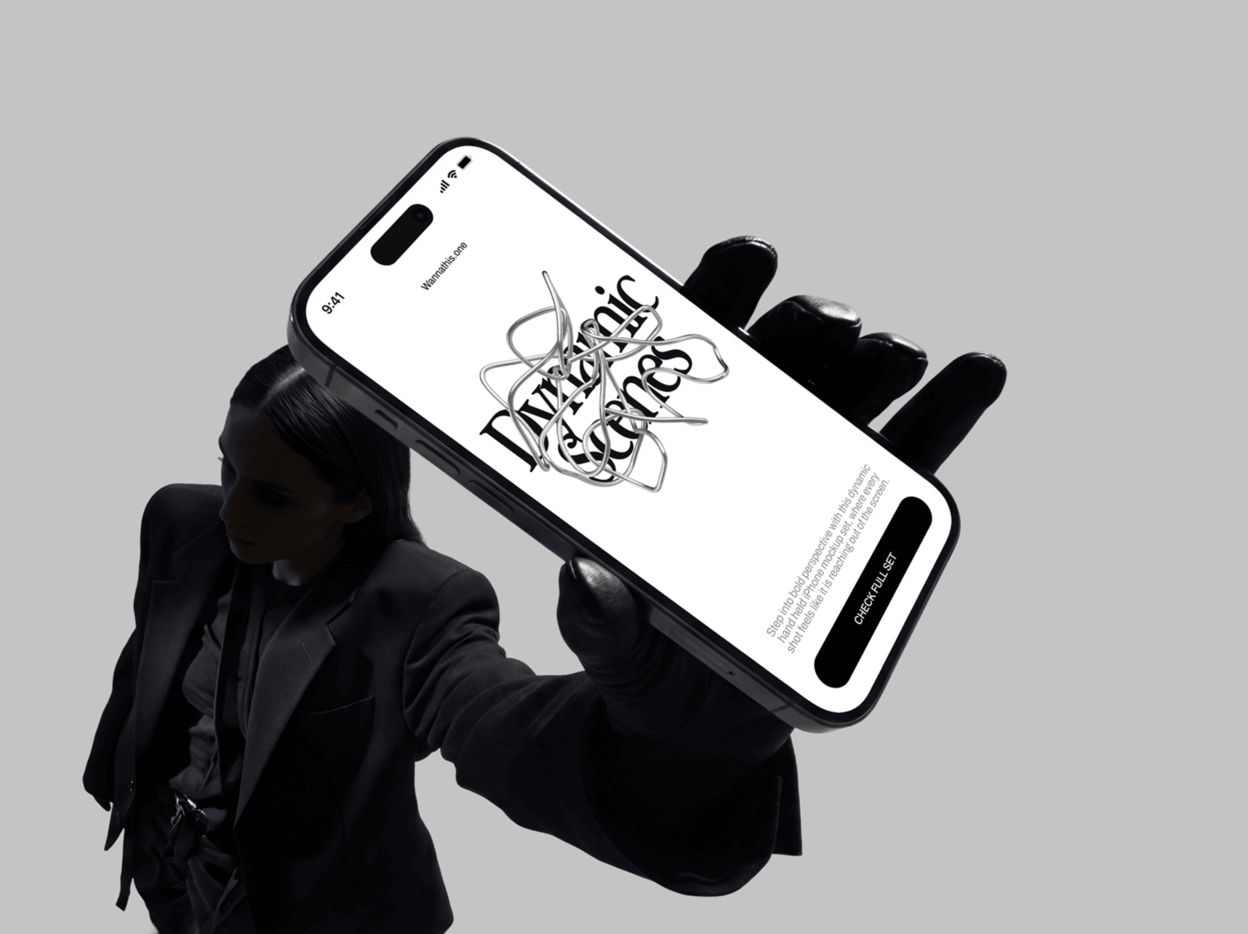 Person holding an iPhone mockup while wearing gloves in an editorial setup