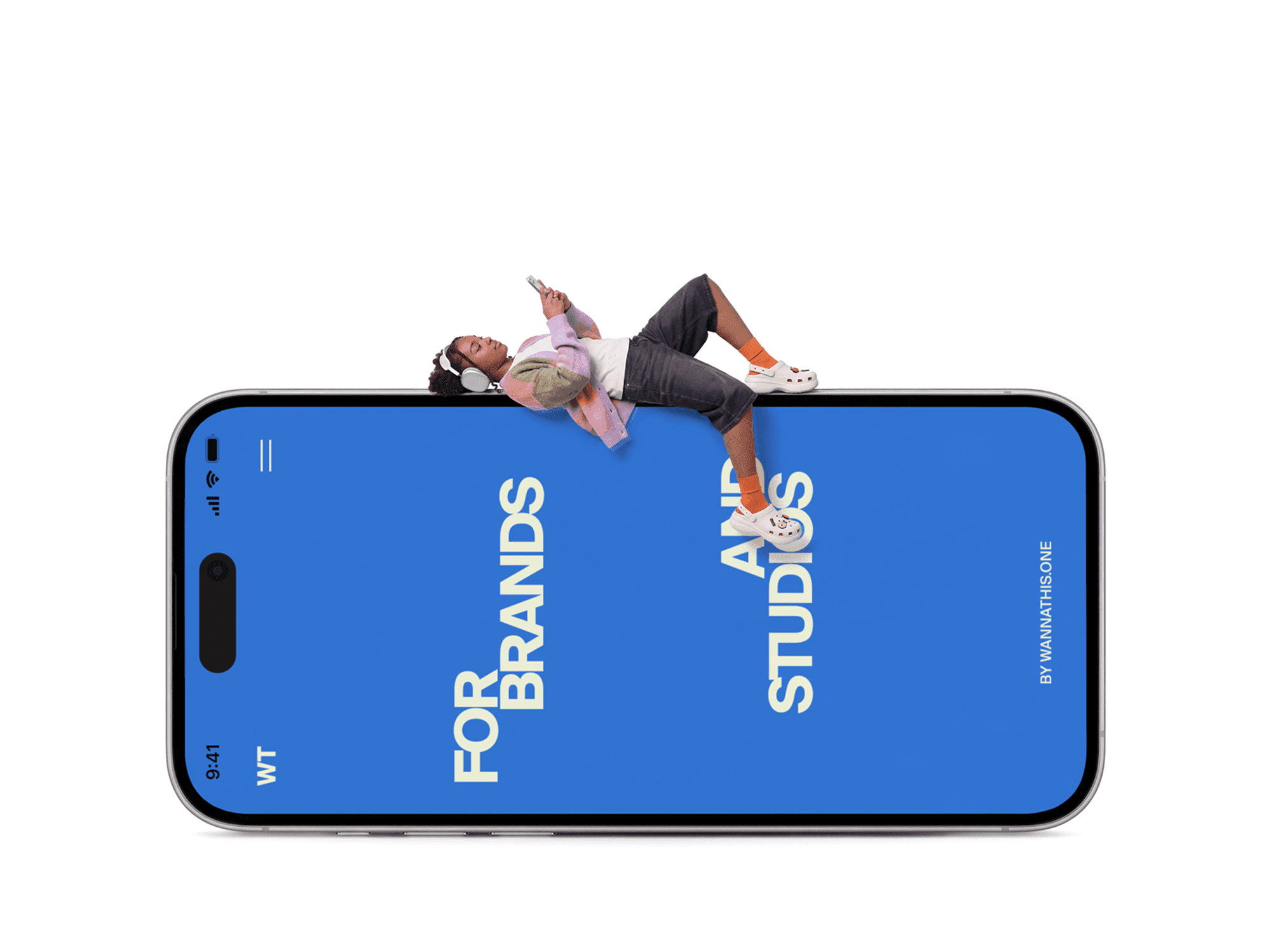 Oversized iPhone lying flat on the ground with a person stretched out on the surface