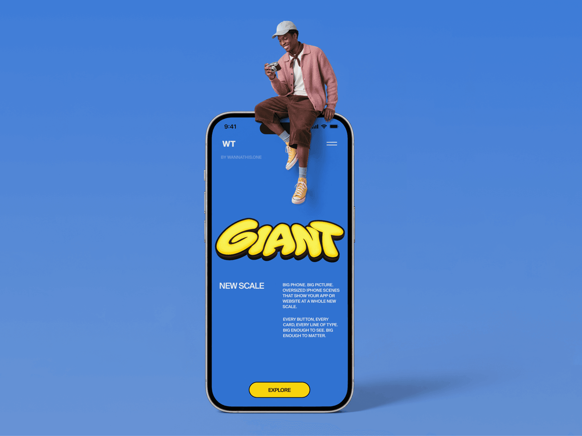 Oversized iPhone standing upright with a man sitting on the top edge