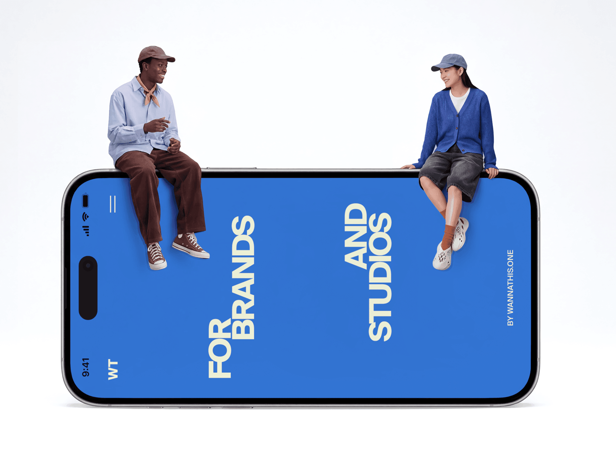 Oversized iPhone lying flat on the ground with two people sitting on the surface