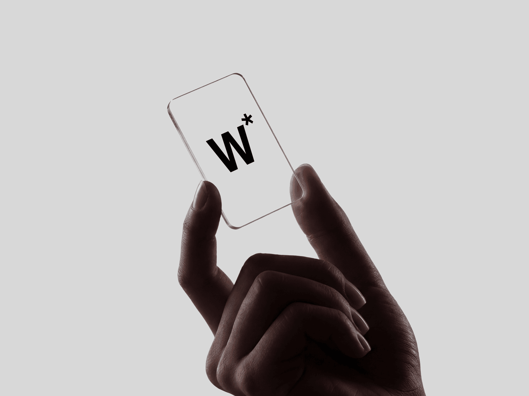 Hand holding a vertical transparent glass card with a pinch grip