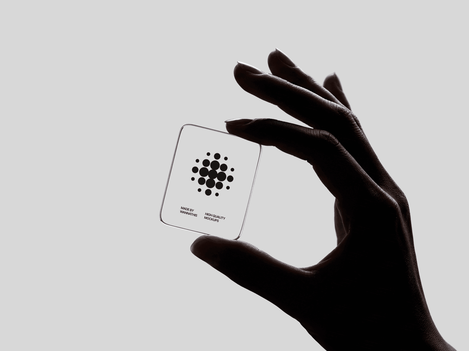 Close-up of a hand holding a transparent glass card between fingers