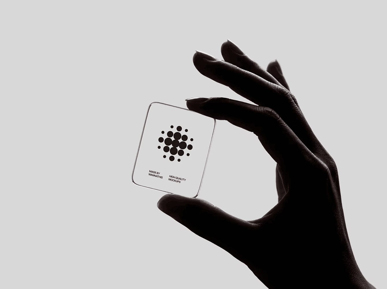 Transparent glass logo mockup held between fingers in low-key lighting — a tactile presentation scene designers use to show brand identity beyond the artboard.