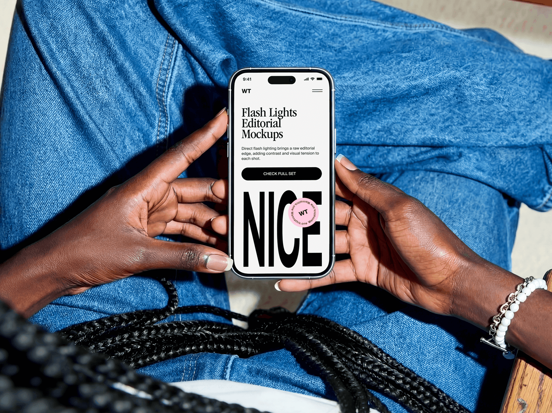 Top view of hands holding an iPhone while seated in a casual indoor setting