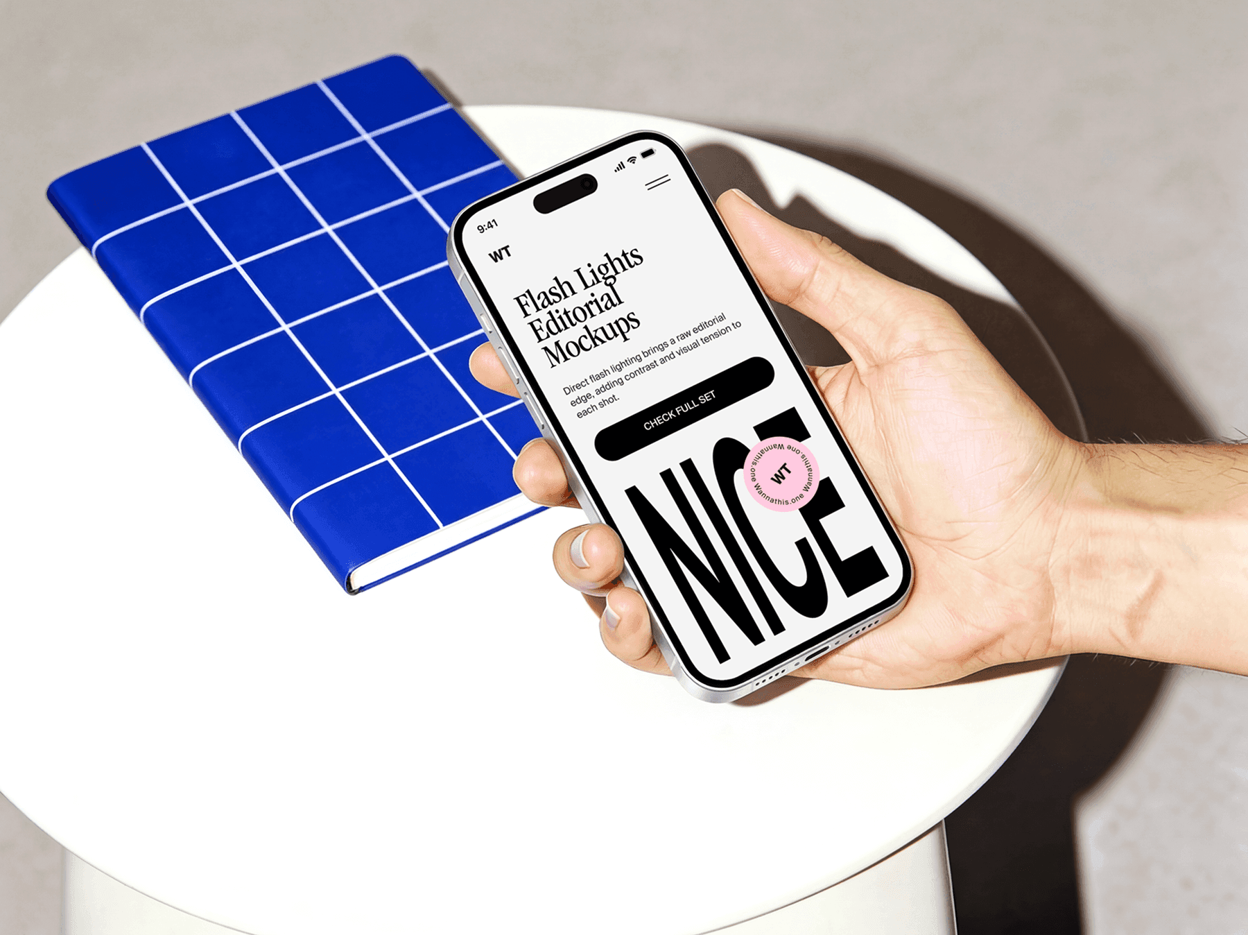 Hand holding an iPhone above a round table in a clean indoor setting