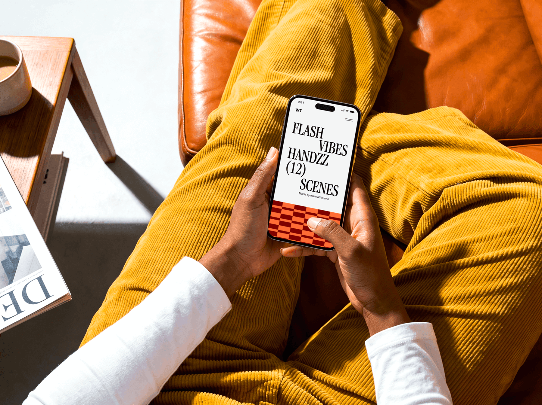 Person seated while holding an iPhone with both hands in a lifestyle setting