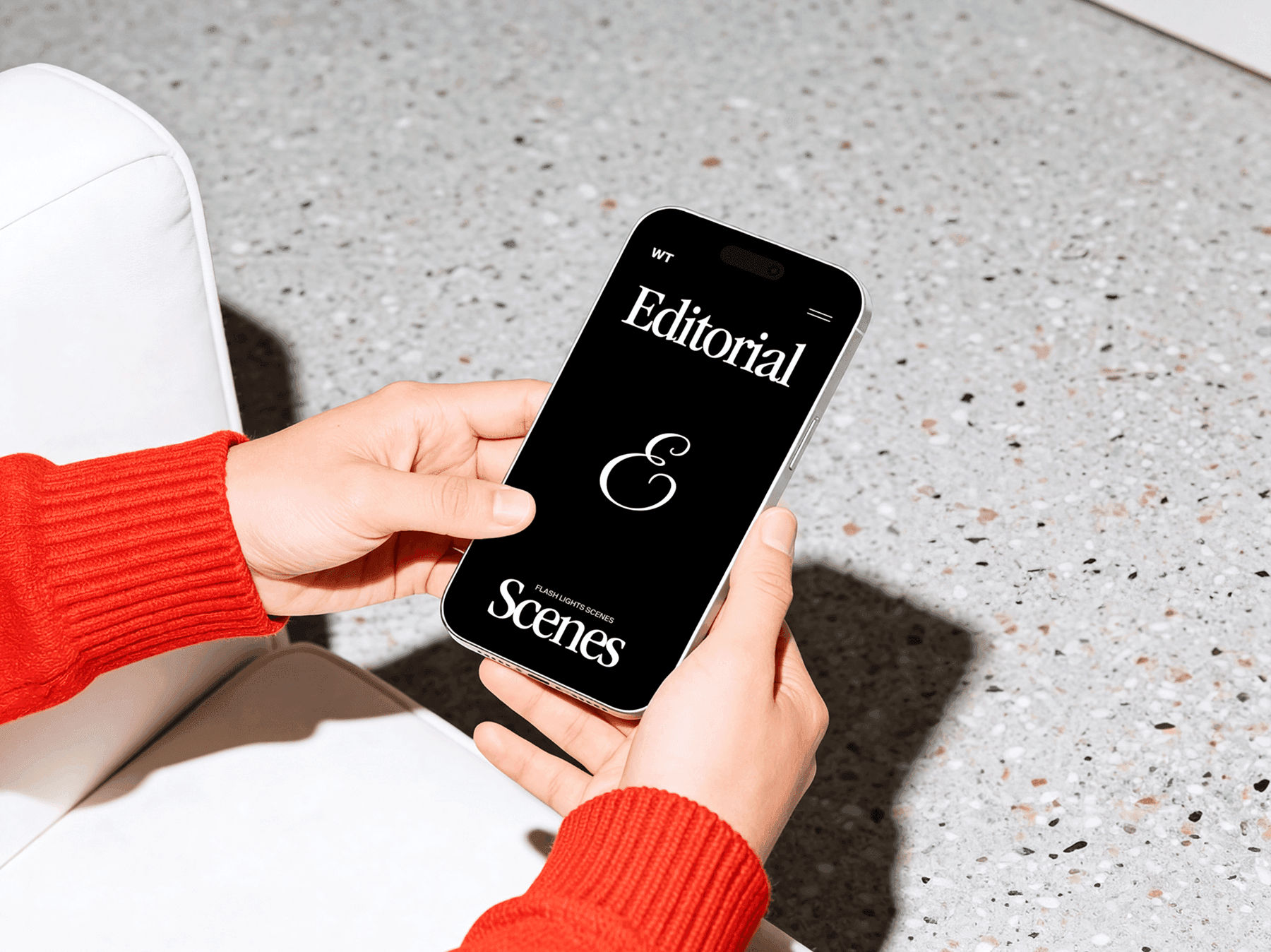 Hands holding an iPhone in a relaxed indoor lounge environment