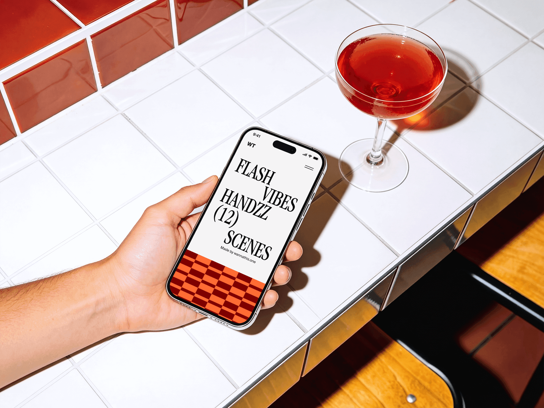 Hand holding an iPhone above a tiled table in a modern interior