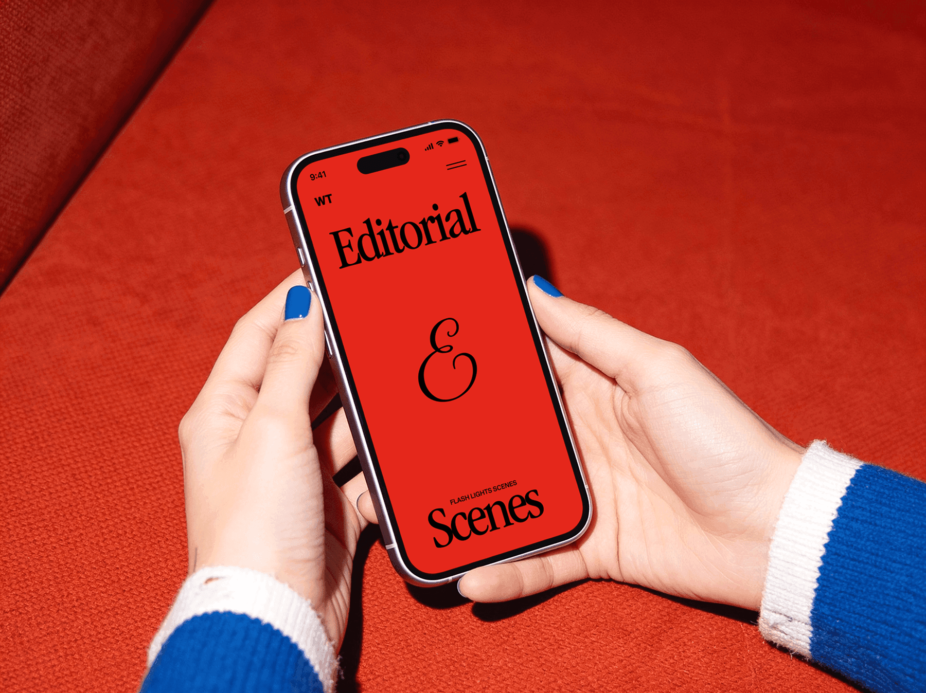 Hands holding an iPhone while resting on a soft seating surface indoors