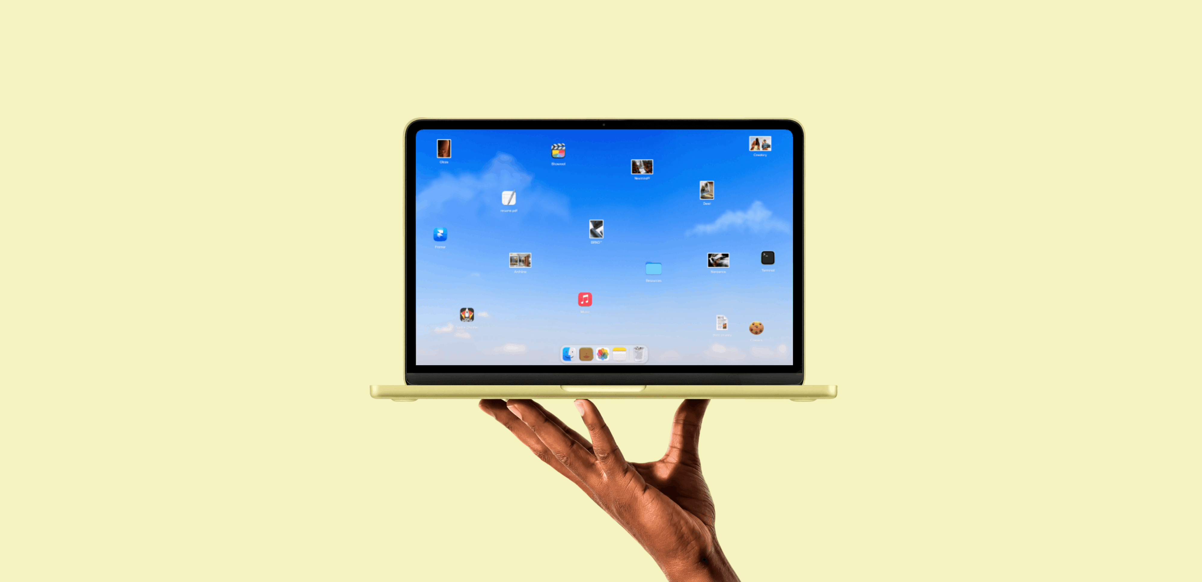 A hand holding a yellow MacBook showing a macOS desktop portfolio layout with scattered project icons, hero image for a roundup of Framer portfolio templates