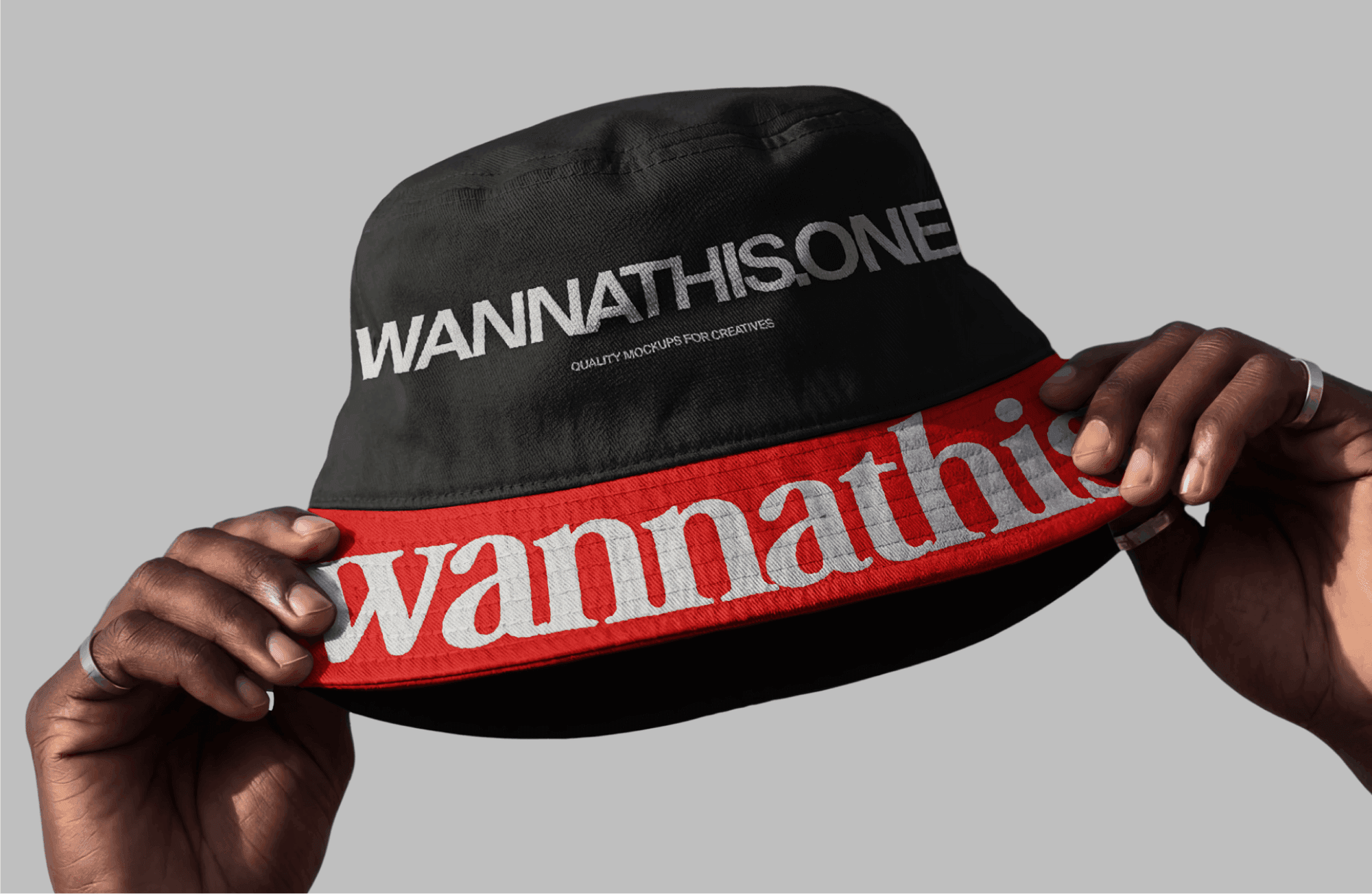 Black bucket hat mockup with embroidered Wannathis logo held in hands close-up