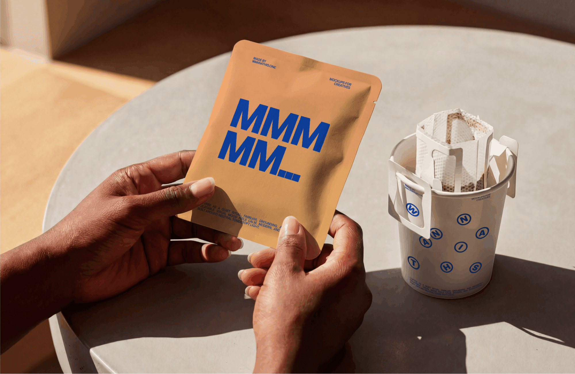 Drip coffee bag packaging mockup held in hands next to cup in warm natural light