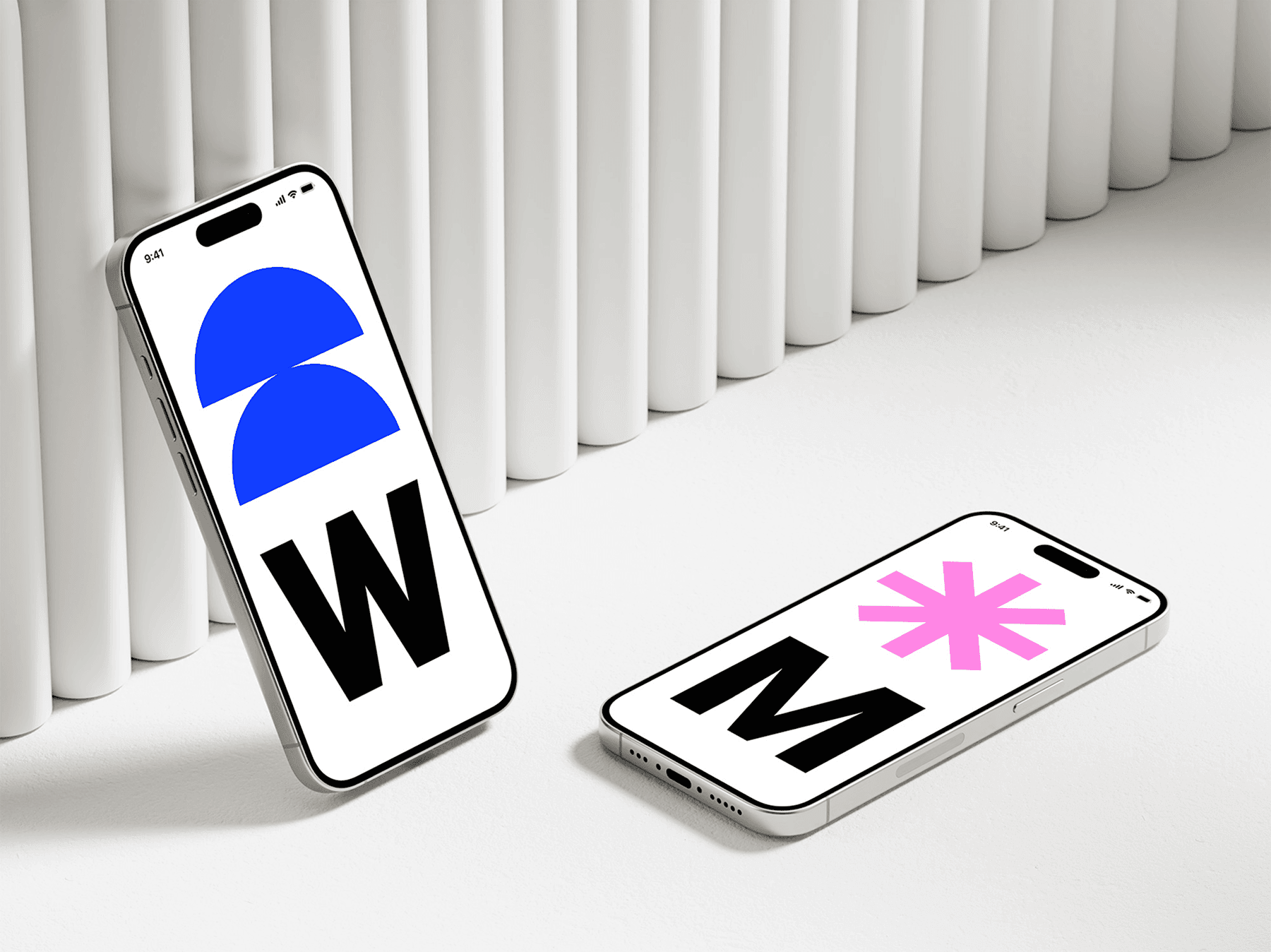 Two iPhone mockups leaning against vertical white panels in a studio setting