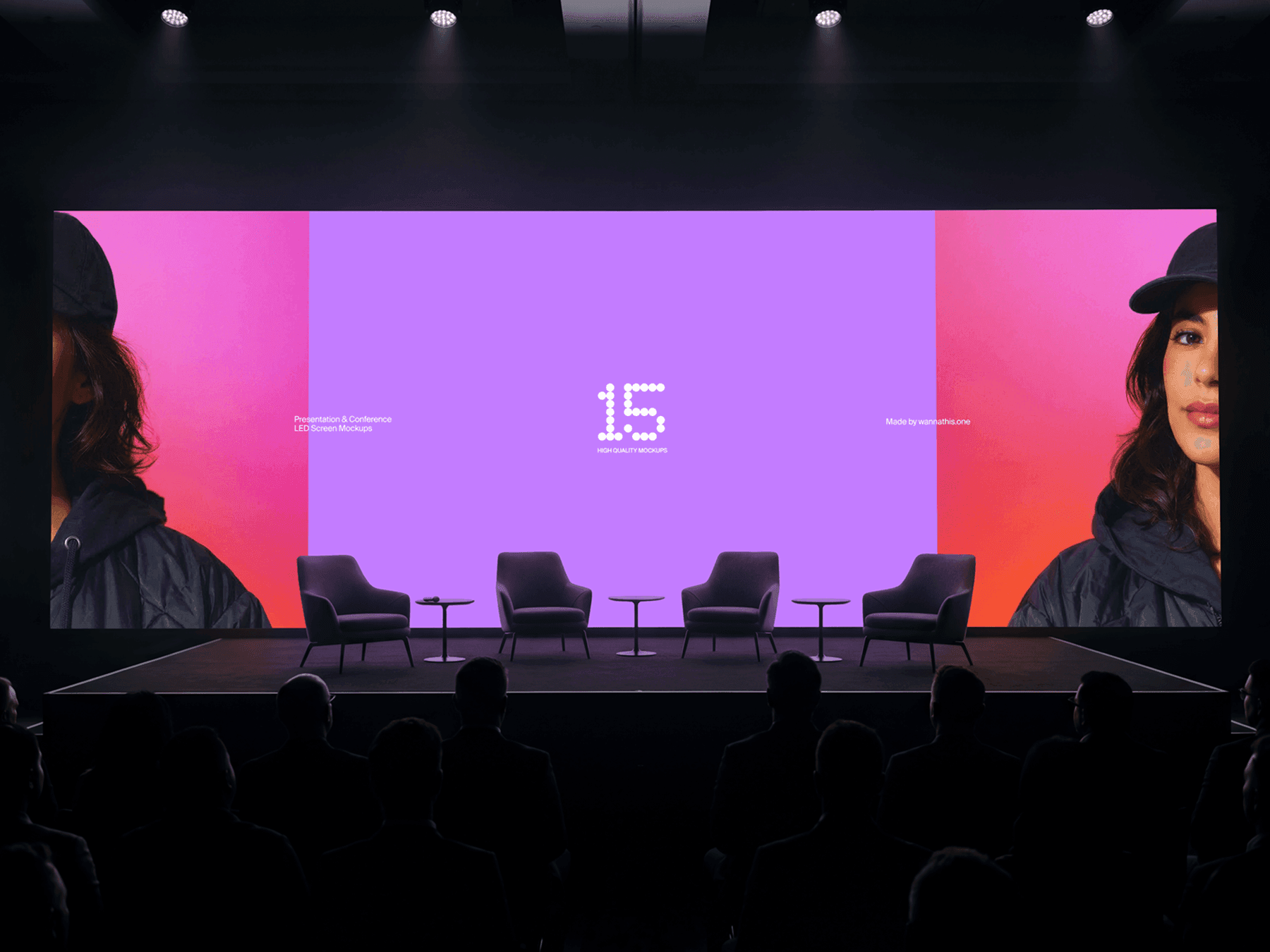 Wide LED screen on a conference stage with chairs and audience in front