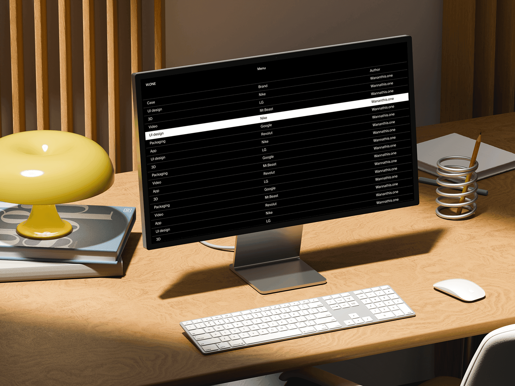 Studio display monitor positioned on a modern wooden work desk with accessories