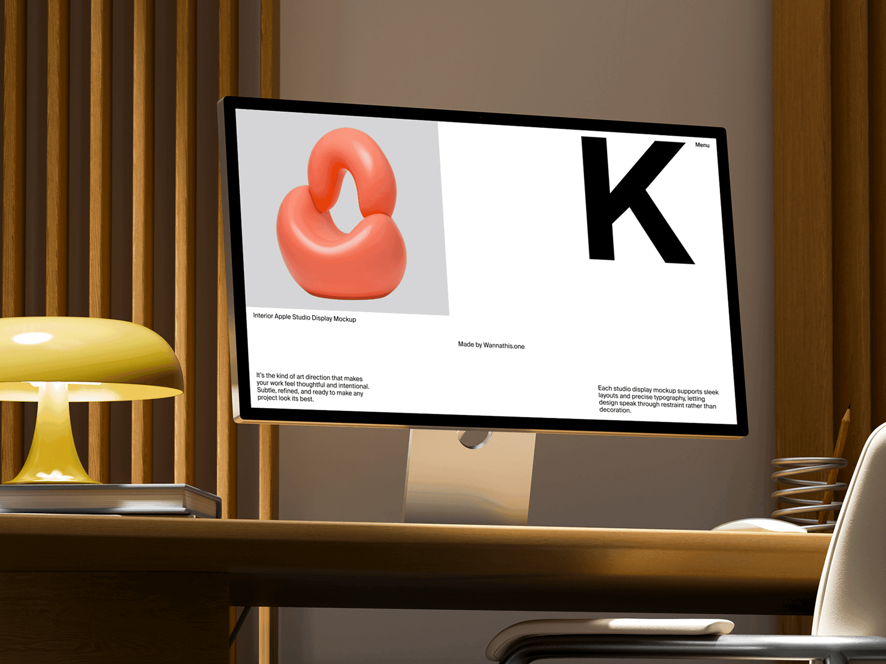 Studio display monitor on a wooden desk with a table lamp and chair