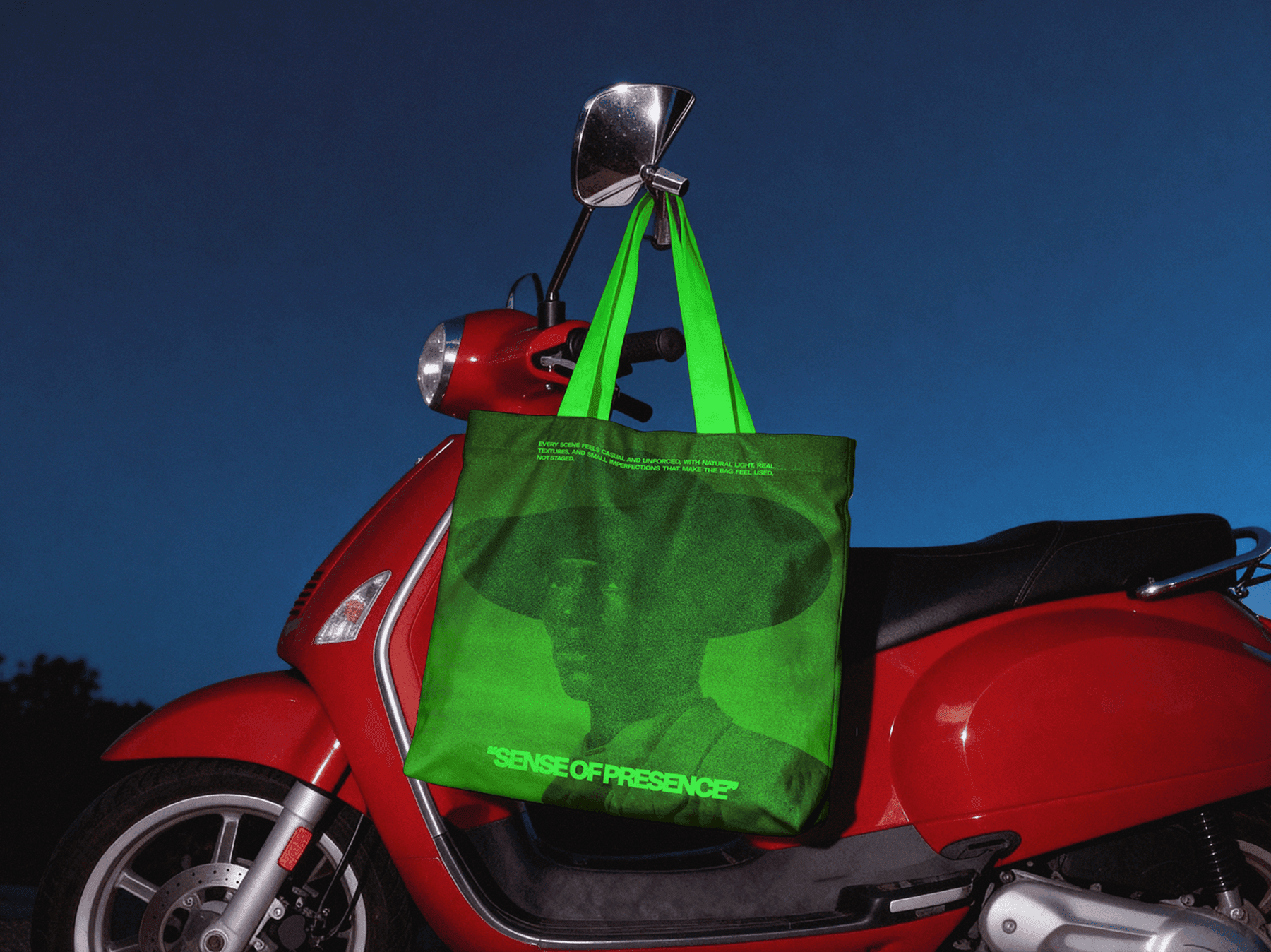 Tote bag mockup hanging from a scooter handle in an outdoor urban setting