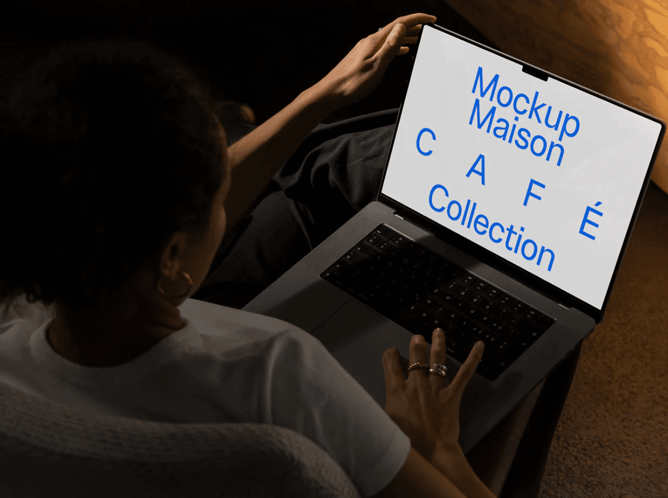MacBook mockup in use with bold blue text on screen viewed from above