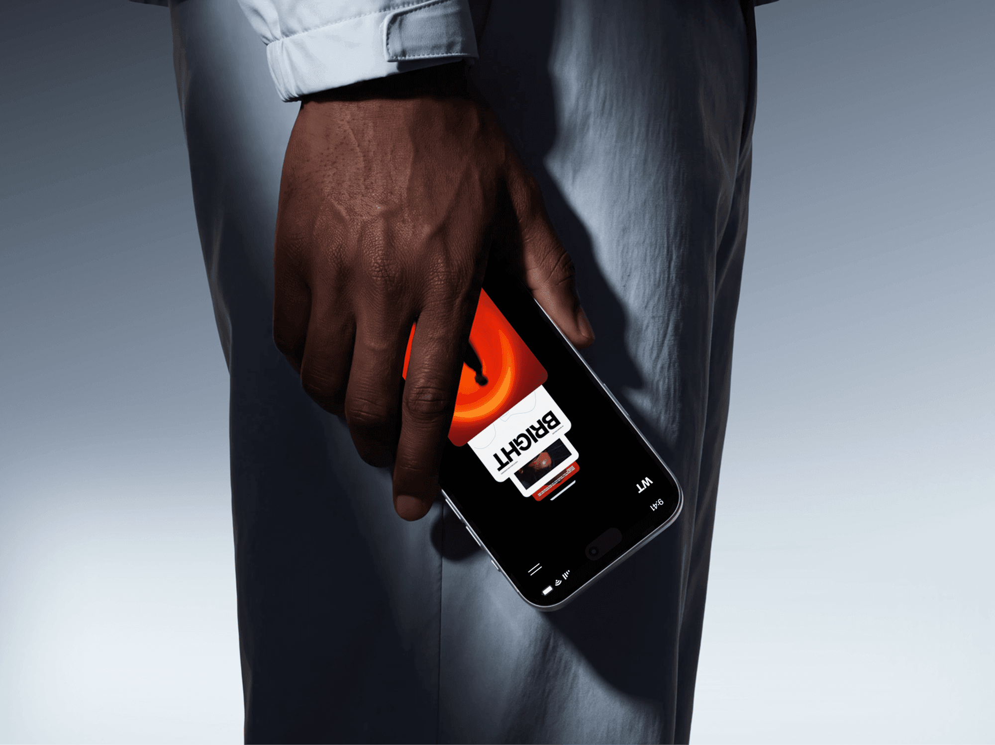 iPhone 18 Pro mockup carried at hip height by a person standing in loose trousers