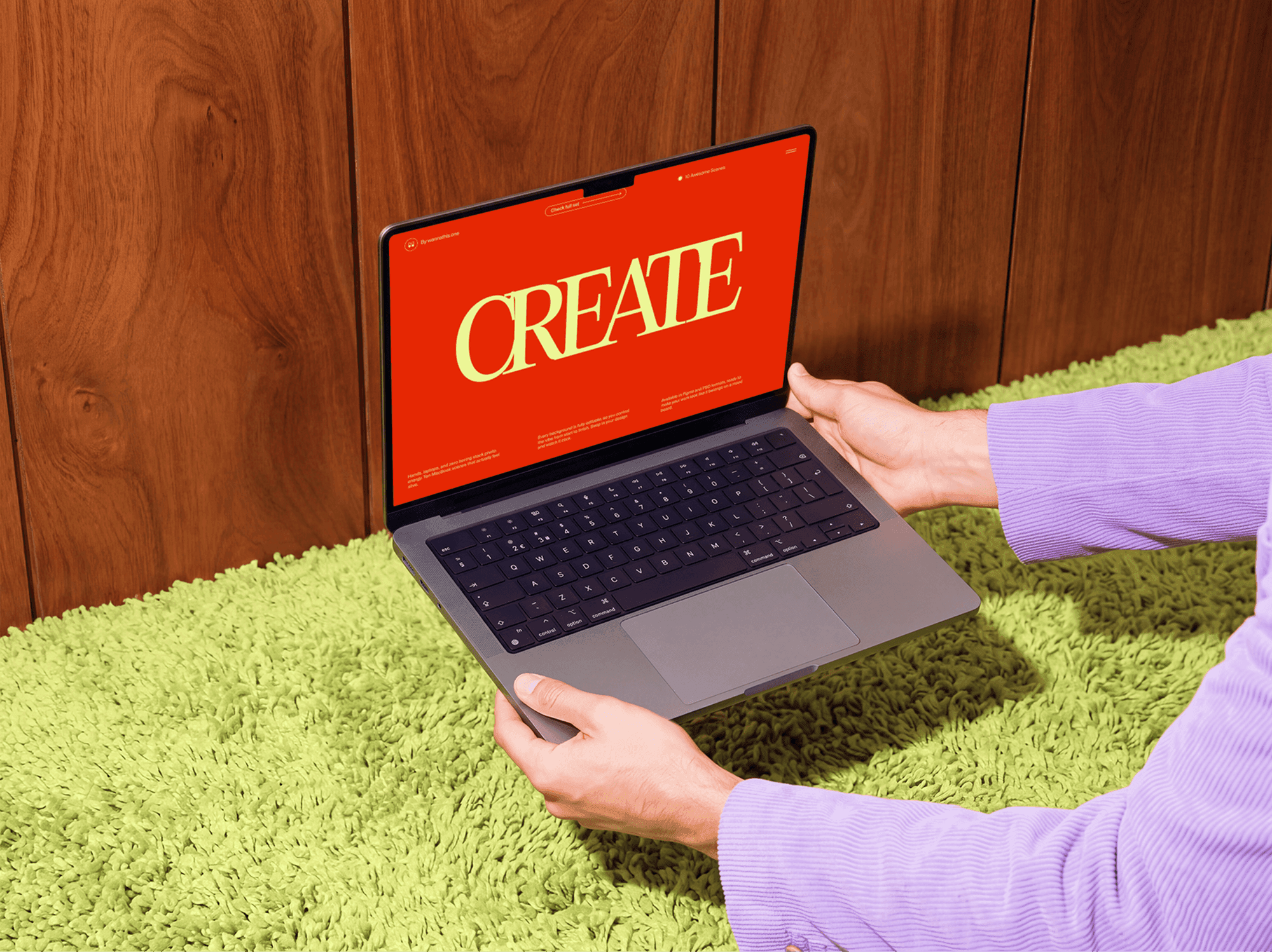 Open MacBook held in two hands above a soft carpet seen from above