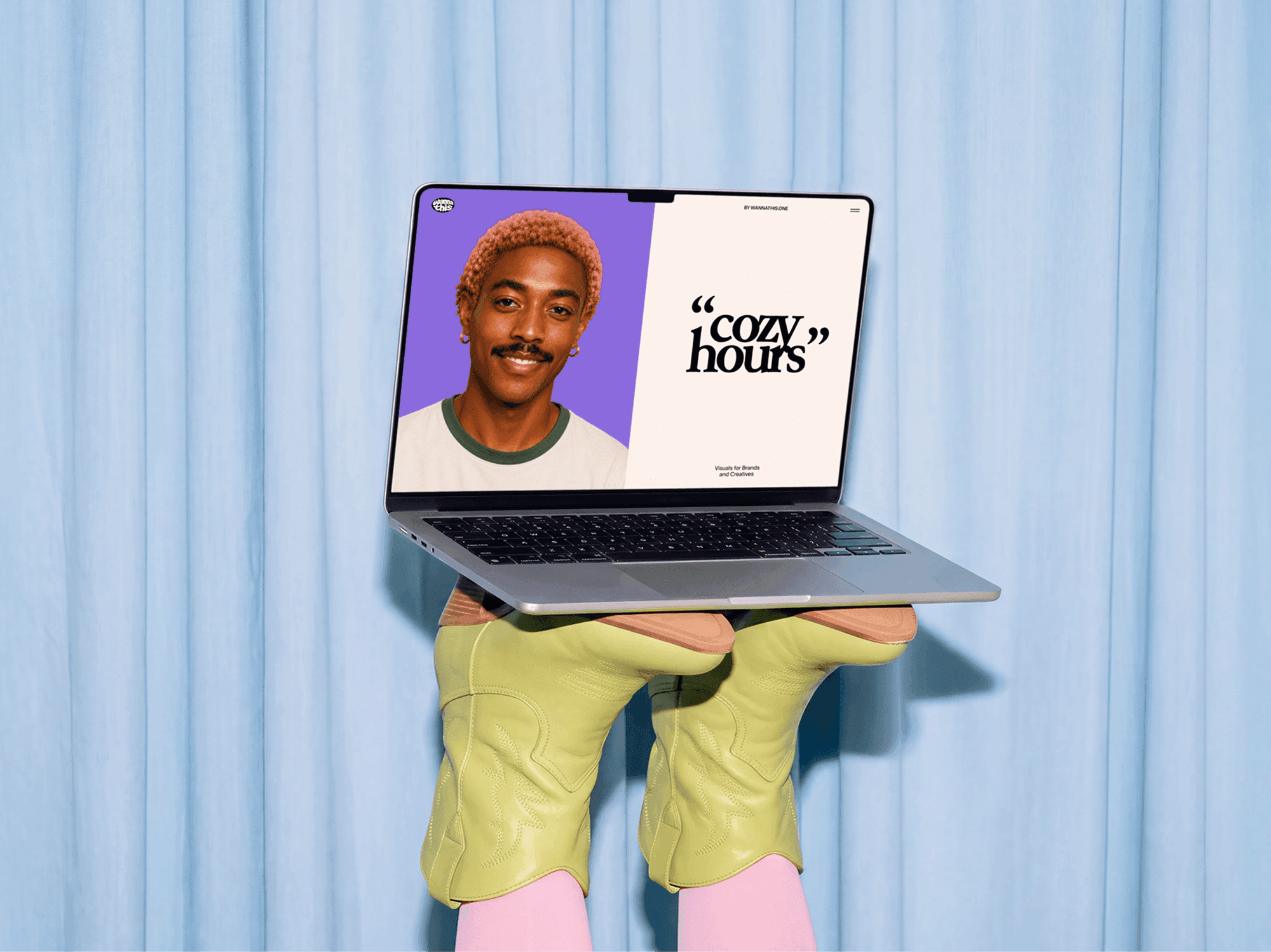 Open MacBook held up in front of a seated person facing the camera