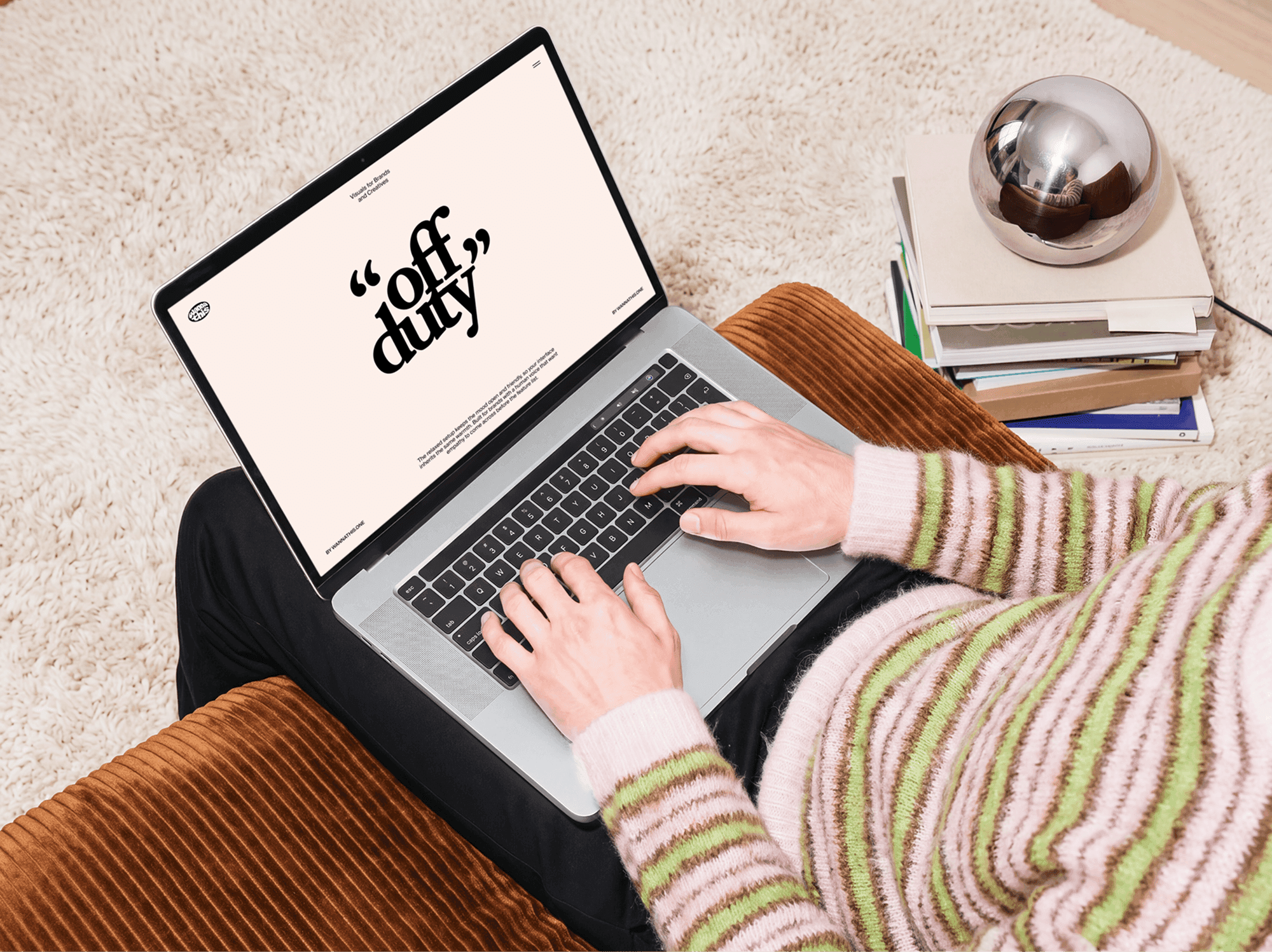 MacBook balanced on a persons lap while they sit back in a padded chair
