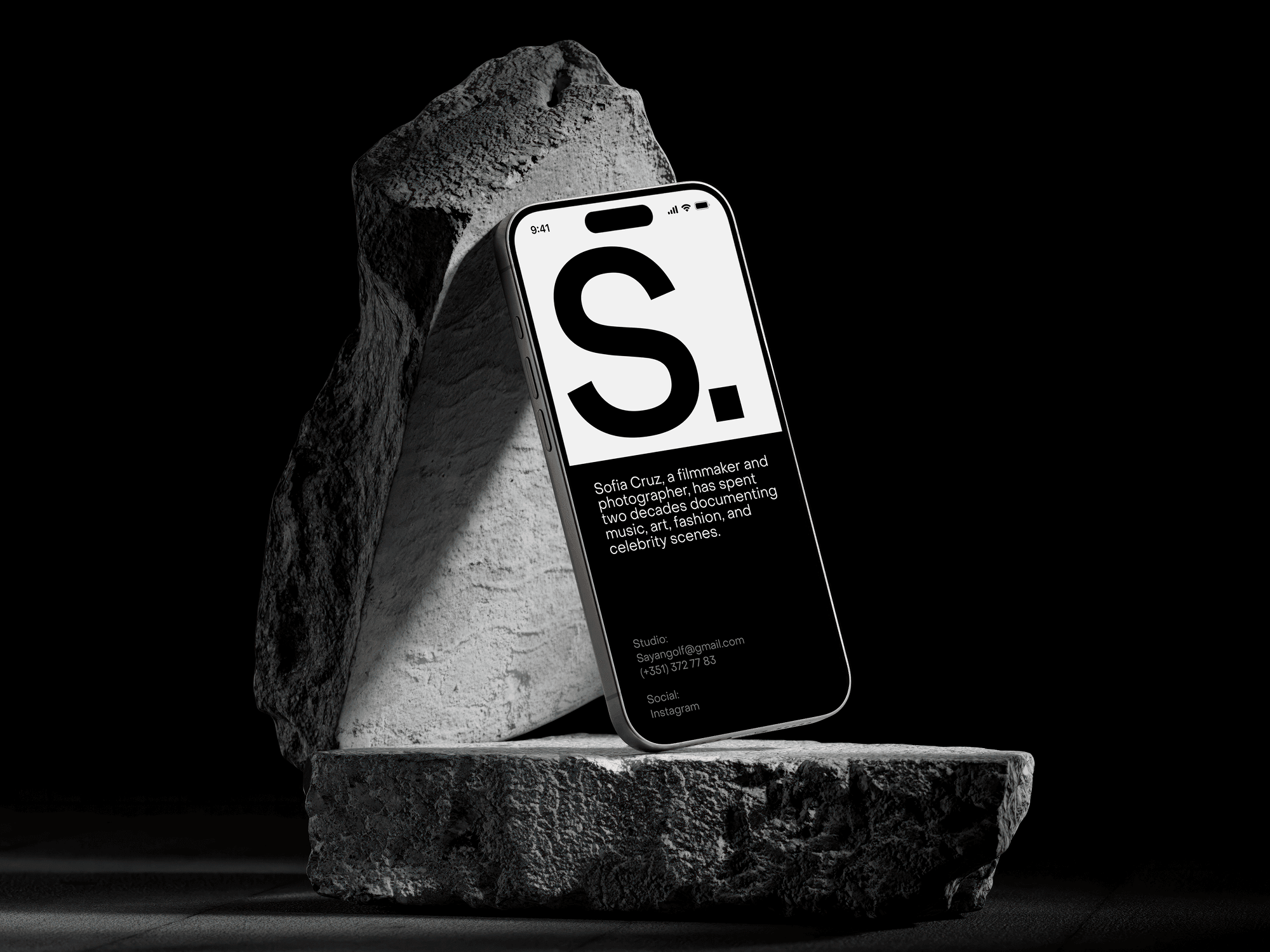 iPhone 15 Pro standing on large stone blocks with a minimalist black-and-white UI