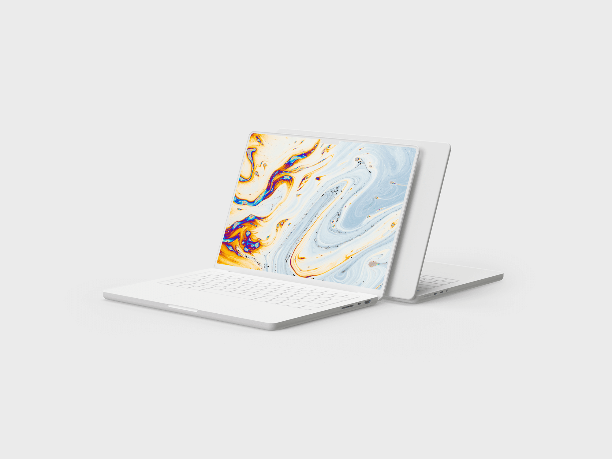 Two white MacBook Pros positioned back to back in a creative composition.